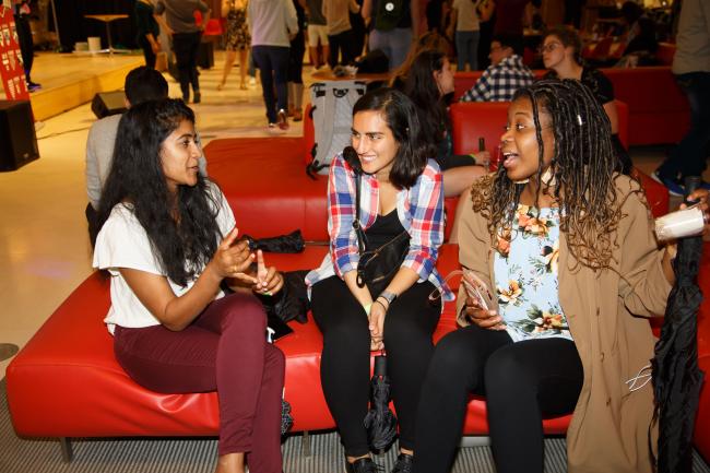 Harvard affiliates sitting together during an event, talking and laughing together.