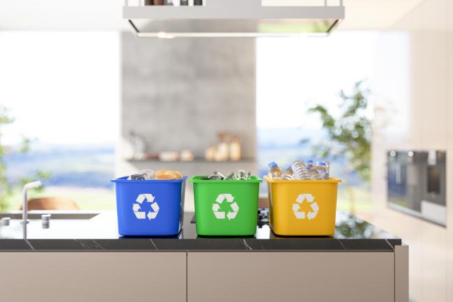 recycling bins of different variations on a brightly sunlit kitchen counter