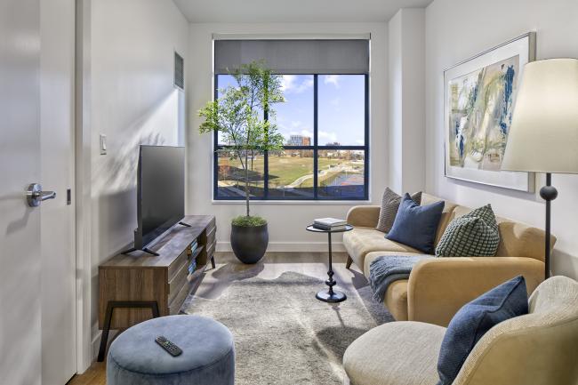 shared living area with mock unit furniture, large window views, and hard flooring