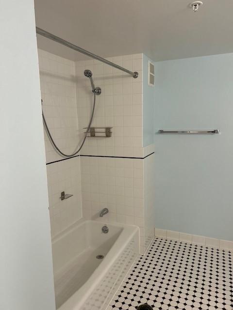 bathroom with shower and tub, tile flooring