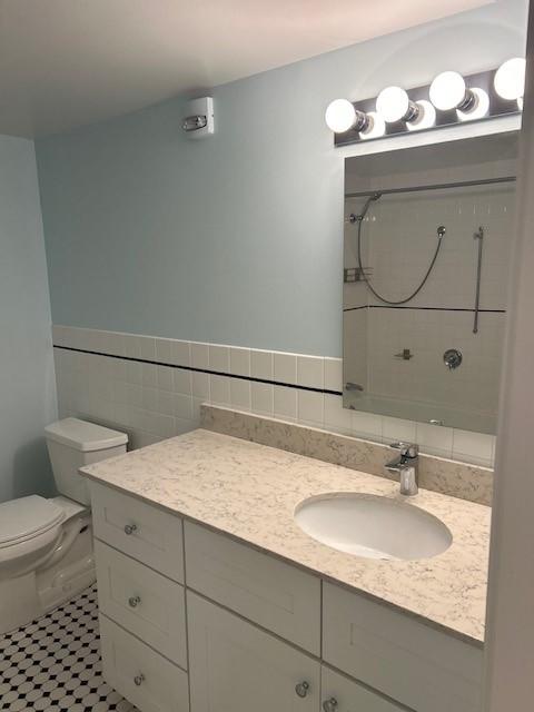 bathroom with tile and large vanity with sink storage