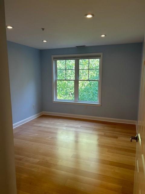 bedroom with wood flooring, large window, and recessed lighting