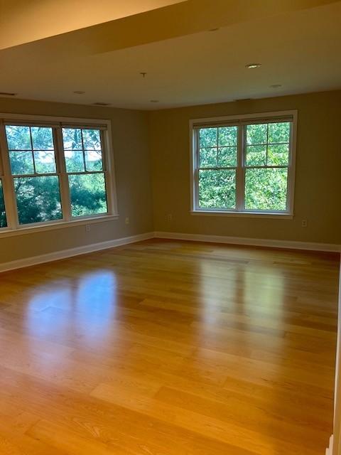 living room with large windows, wood flooring, and recessed lighting