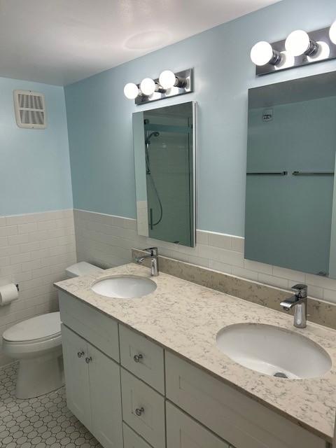 bathroom with dual vanity, complete with double sinks and storage.