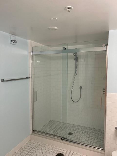 bathroom with tile and stand up shower, glass shower sliding door