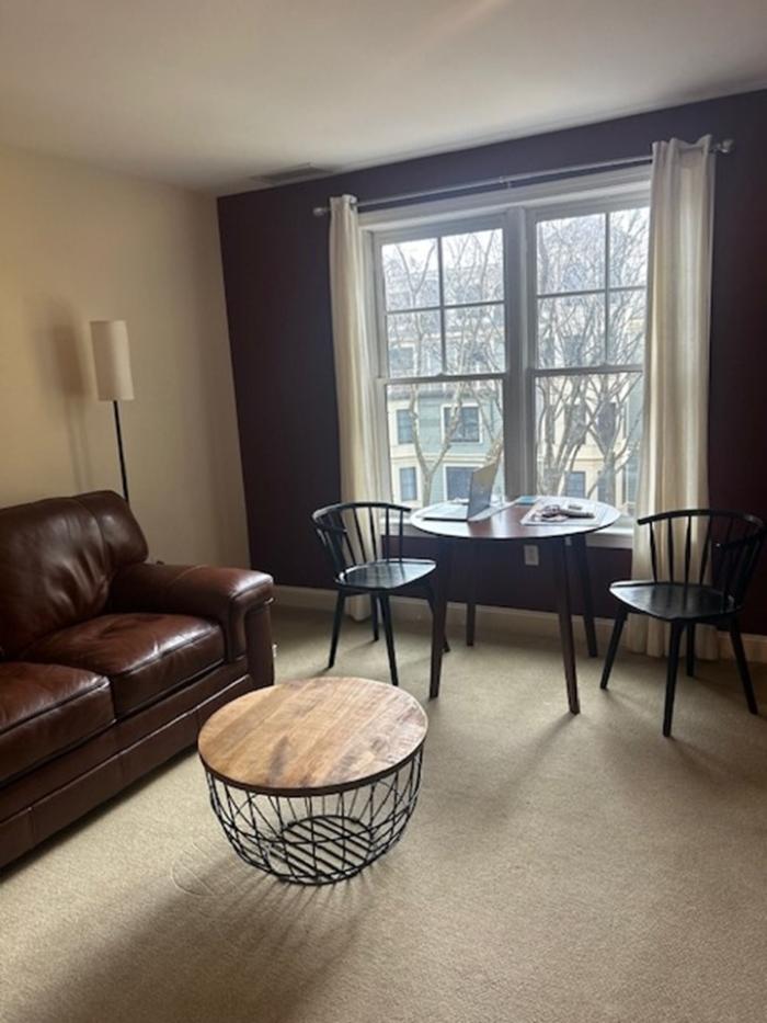 Living and dining area, carpeted floor with large windows. Front view facing the windows.