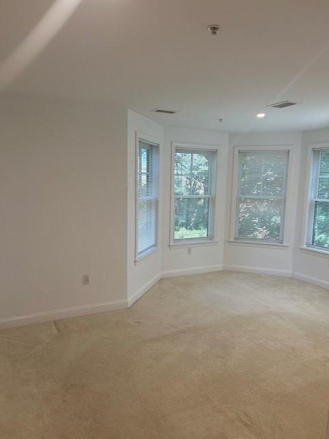 primary bedroom with large bay windows and nook, carpeted.