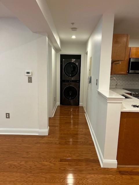 Hallway to entry, hard flooring, kitchen on the right.