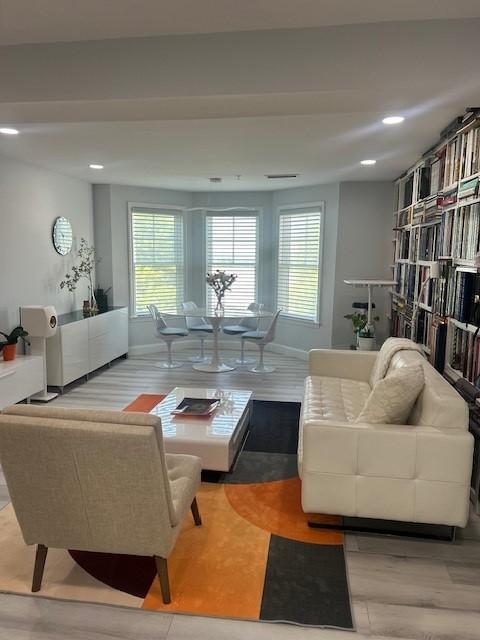 living room with large bay windows and hardwood flooring