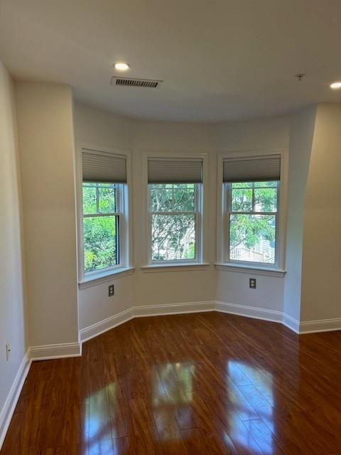 second bedroom with hard flooring, recessed lighting, and large bay windows