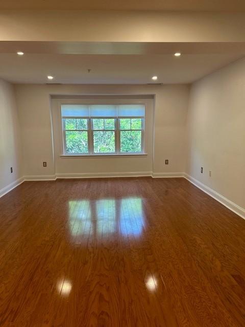 Living and dining area with hard flooring, recessed lighting, and large windows