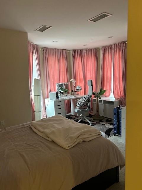 Primary bedroom with carpeting and bay windows