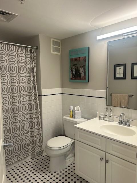 Secondary bathroom with tile flooring, white toilet, shower/tub, sink and vanity