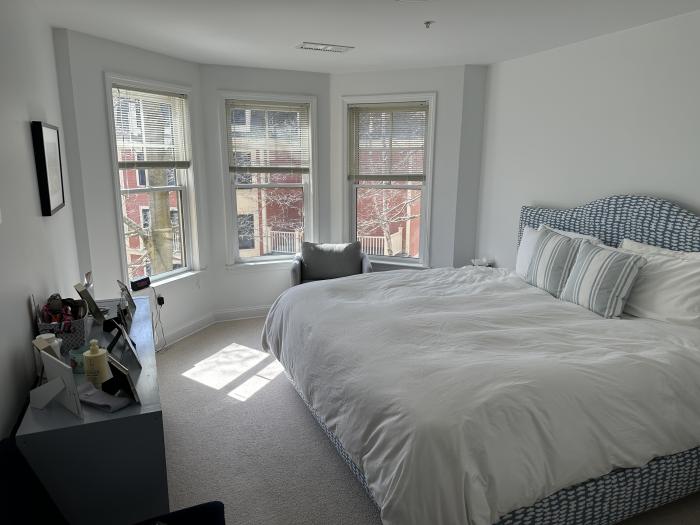 Bedroom with 3-paneled bay windows, carpeting, and overhead lighting