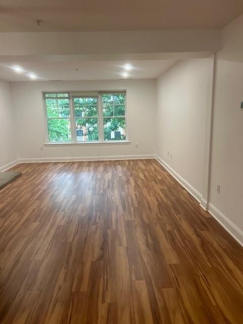 combined living and dining room with hard flooring, large windows, and overhead lighting