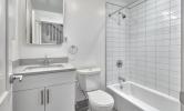 a sample bathroom in 5 Sacramento with white tiled shower/tub, vanity, and toilet