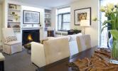 A cozy living room with fireplace, furniture, and hanging wall art work.