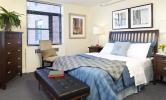 A bedroom with comfortable looking bed and furniture.