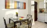 A kitchen with chairs and table.
