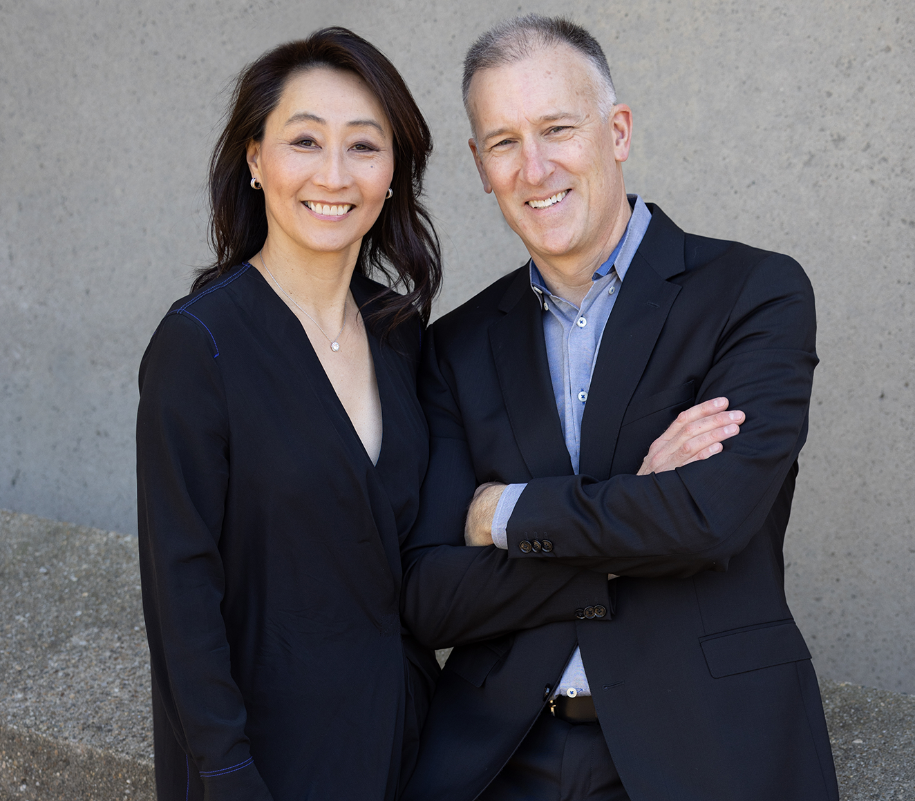 Faculty Directors Grace La & James Dallman smiling and posing together.